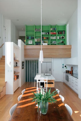 A double-height kitchen and dining area accommodates the change in slope of the site.