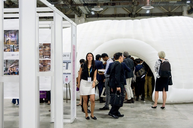 Crowds spilling out of an inflatable presentation pods into the exhibition area.
