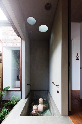 An in situ concrete bathtub scoops down in graceful, ergonomic lines, the space reminiscent of Japanese bathhouses.