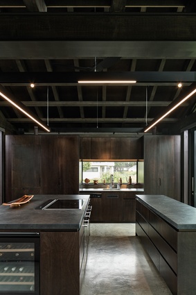 The kitchen, which engages directly with the internal courtyard, has parallel, slate-topped island benches so there’s space for everyone. The long strip lights are by Flos, from ECC.