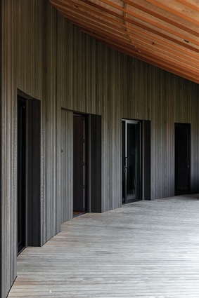 Simple aluminium joinery reads as breaks in the stained Western cedar walls.