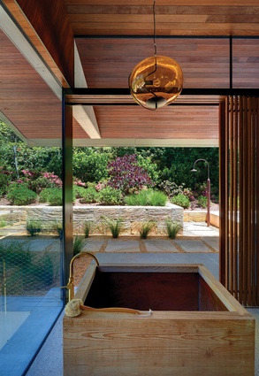 A bathhouse on the ground floor features a Japanese timber tub and is open to views of the garden.