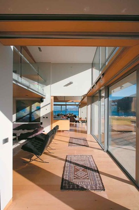 Looking through to the kitchen and dining area of this Wanaka house, from the lounge with mezzanine space above, designed by John McCoy.