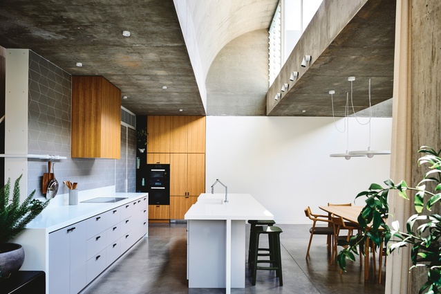 A wave-like concrete roof profile creates interest while allowing sunlight into the kitchen and living area.