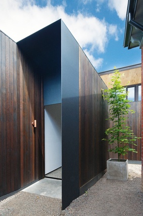 The informal entry is located next to the garage, the dark timber and black steel creating a protected doorway that leads into the living area.