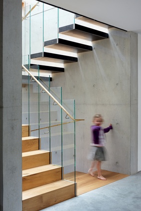 A glass balustrade enhances the sculptural quality of the main staircase. 