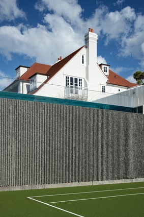A balustrade by the pool has cantilevered white steel fins. The pool wall is acrylic.