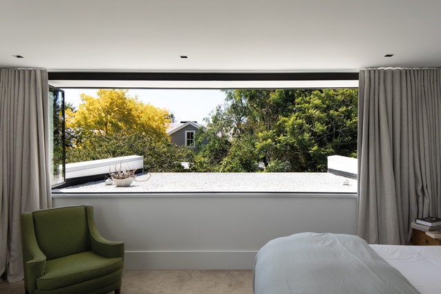 The north-facing master bedroom overlooks a white-pebbled roof line.