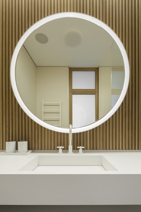 Rounded edges in the form of mirrors and lighting provide an art deco look to the spaces.