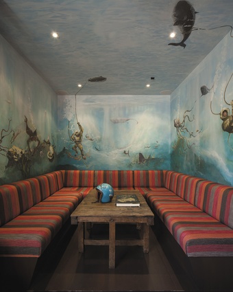 A booth with underwater mural and colourful linen seating provides a visual high-point within the woody interior.