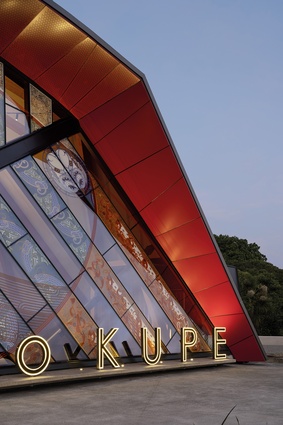 The exterior of Taumata o Kupe is enlivened by uplighting and illuminated lettering as day moves into night.