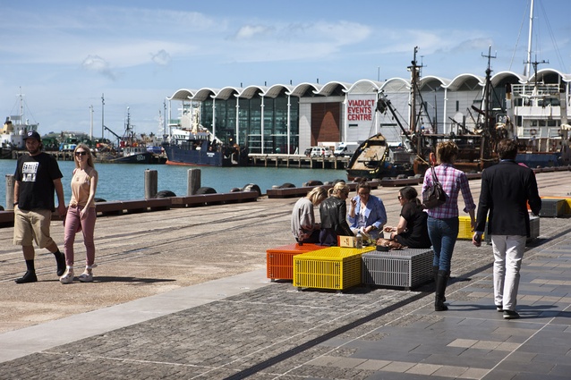 Crate seats provide public seating elements along the north wharf promenade edge. Fine grain granite setts blur the boundary between private and public space.
