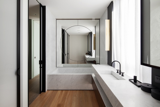 A Michael Anastassiades Tube wall light can be seen in the bathroom. 
