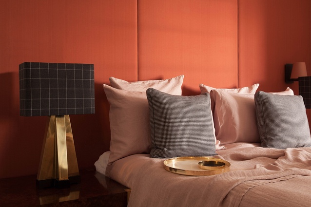 Custom panelled upholstered headboard in salmon cantaloupe, 1970s vintage lamps with cashmere wool shades, washed blush linen bedding with custom wool cushions. 