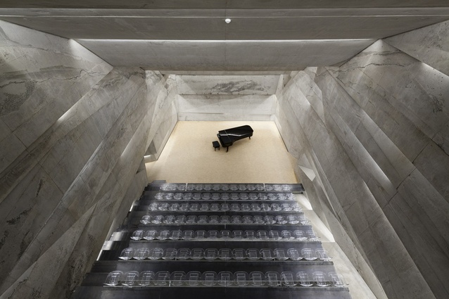 Blaibach Concert Hall, Germany by Peter Haimerl Architektur. The tilted concrete surfaces are based on acoustic specifications and bass absorbers are hidden behind the light slits and under the stairs.