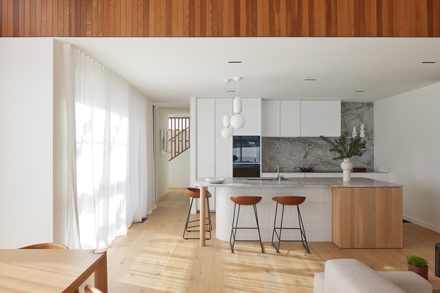 A curved kitchen island bench end provides for conversational seating, while a mix of oak veneer and half-round solid oak dowels anchors it at the other end.