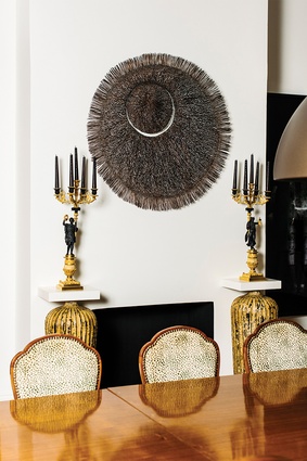 Bronwyn Oliver’s <em>Eclipse</em> sits above the fireplace in the dining room, bookended by a pair of Louis Philippe’s period French candelabra, circa 1835–1840.