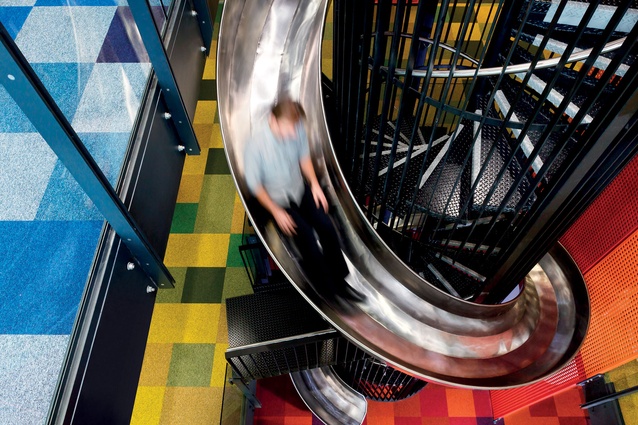 Staff whiz down a three-levelled spiral slide and staircase between levels five and three. 