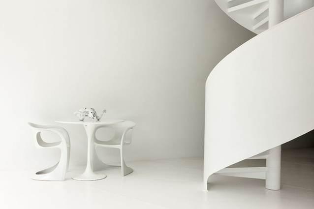 The ribbon-like single helix stair is complemented by a grouping of curved sculptural furniture. 