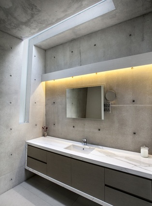 The concrete bathrooms bring the exterior bunker aesthetic indoors. 