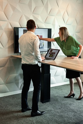 The signature pattern appears again – in acoustic panelling – within a meeting room. The table is sit-stand adjustable, and the touch screen wirelessly pushes content from laptops.