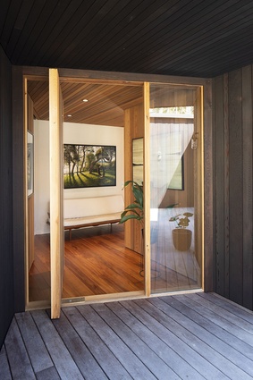 Dark-stained cedar used for the exterior cladding gives way to the honeyed hues of natural timbers inside.