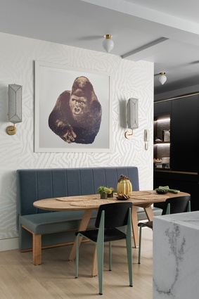 An Enzo Mari gorilla print, with sconces by Erich Ginder on either side, hangs above the kitchen table.