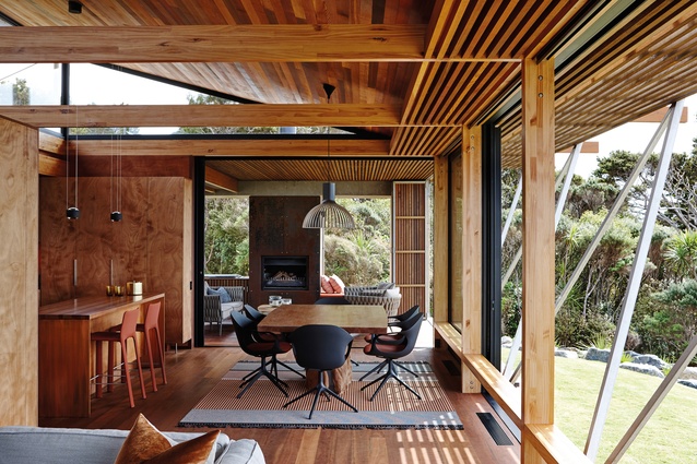 Sliding doors link the dining area to a lanai (the Hawaiian word for covered verandah) while sliding windows open up the frontage for close connection to the sea and bush backdrop.