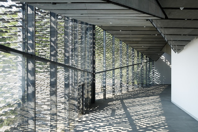 China Academy of Arts. The outer wall is covered with a screen of differently-sized recycled tiles hung up by stainless wires, controlling the volume of sunlight coming into the interior.