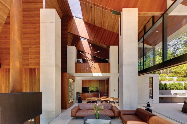 A skylight in the high ceiling cuts the house in two along its longitudinal length, “axing the space surprisingly and splitting a volume like a log.”