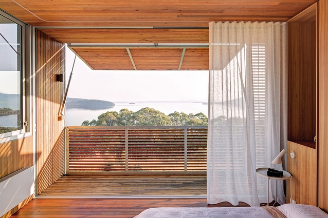 Operable screens adjoining the upstairs bedroom provide shade and capture views to the lake.