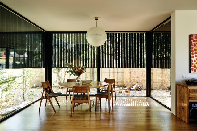 Timber battens extend from the facade over the dining room’s glass walls, aiding privacy.