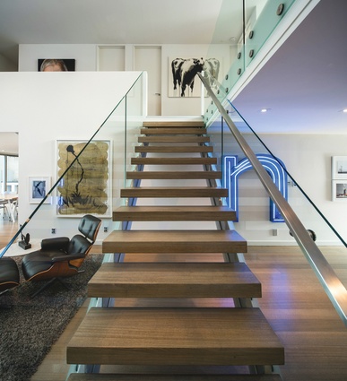 A ‘floating’ staircase punctuates the double-height space leading to the bedrooms and the mezzanine lounge.
