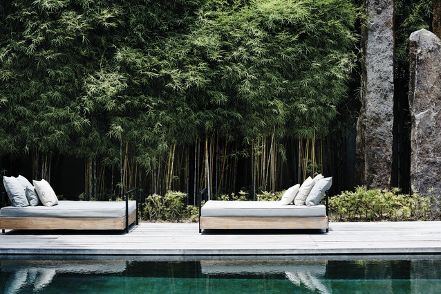 Bamboo lines the pool, along with monolithic stone sculptures. Day-bed cushions are from 
BoBo Living.  