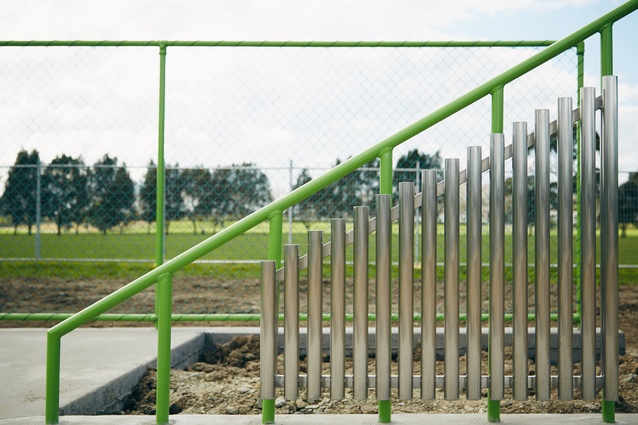 A fence incorporates a xylophone and holes, acting as kicking targets. 