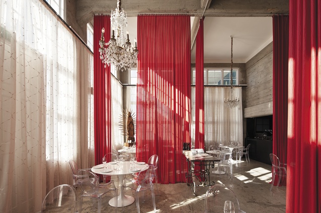 A light-filled room that features ceiling-to-floor drapes in a confident red.  