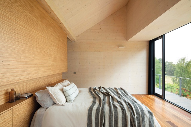 In the master bedroom, plywood joinery continues the home’s timber focus.