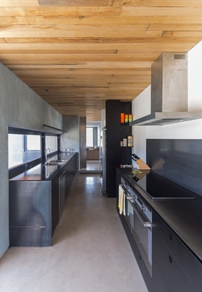 The kitchen’s palette is kept simple, consisting of timber, steel, black laminate and concrete.