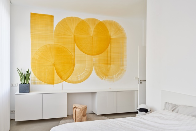 The artwork is <em>One Yellow Line</em> mural by designer and artist Thomas Trum, who often works with a singular line. For this piece, he created a giant felt-tip pen that he dragged down the wall in one motion. 