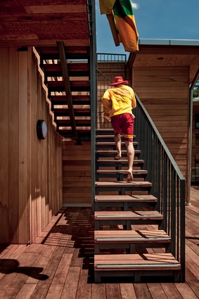 A lifeguard runs up external stairs to the patrol tower. The new clubhouse will help its trained lifesavers to protect swimmers along this stunning coastline.  