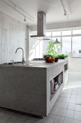 The elegant line of the furniture and the warmth of wood are contrasted with a Modernist materiality of concrete, steel and glass in the kitchen.