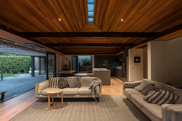 The living room interior space sits below a timber-lined ceiling and a central lightwell. 