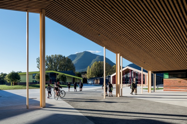 Students occupy the entrance canopy, which is a perfect frame for the local maunga Putauaki. A learning house is seen to the left-hand side.