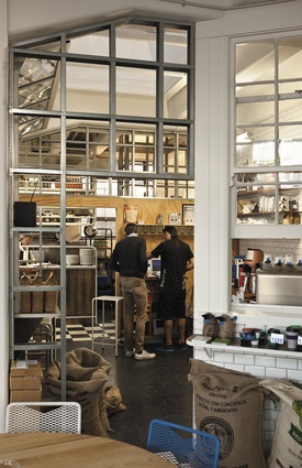 A view into the coffee roastery on display in the heart of the café. A skylight, out of shot, is a surprising building feature that provides abundant natural light.