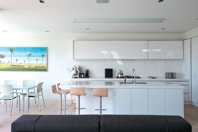 In the kitchen, the house’s white palette aids the distribution of natural light.