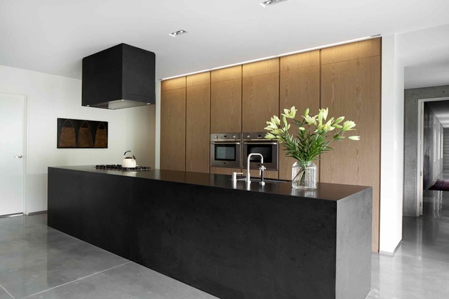The solid black island and range hood create a sense of visual strength and solidity. 