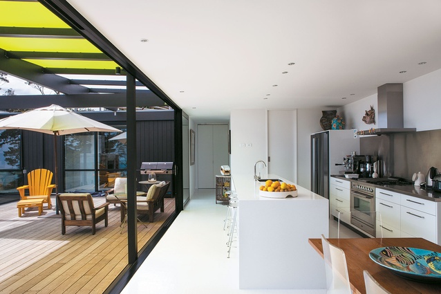 The kitchen opens onto a large deck sheltered by lime-green polycarbonate panels.