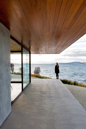 While the house “floats” on the land’s edge, the solid materials lend a grounded feeling.