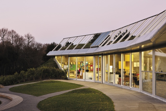 The north elevation at dusk, with learning environments fringing the  playground.