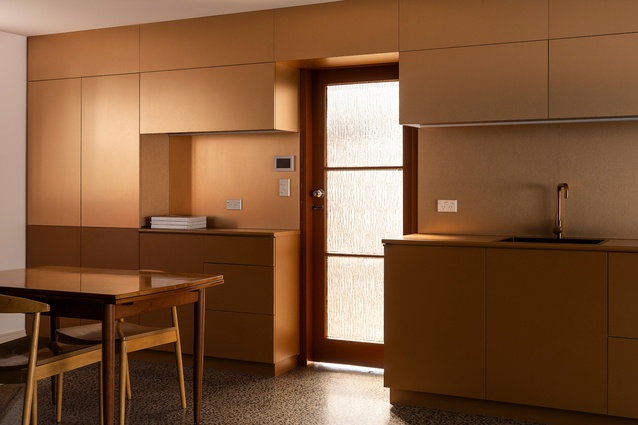 The functional studio kitchen is essentially a wall of handle-less cabinetry, with the top panels disguising the bulkhead. The existing fluted-glass door was retained. 